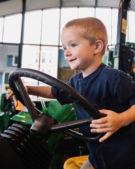 A kid sitting on a tracker 
